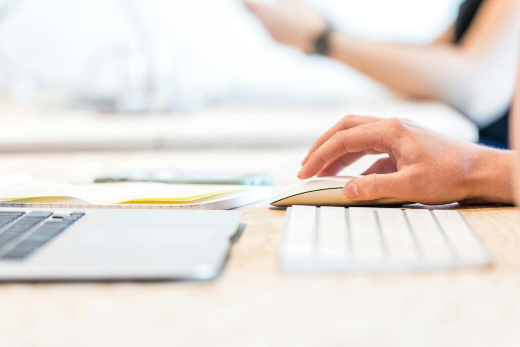 Gros plan sur un clavier et une main tenant une souris d'ordinateur