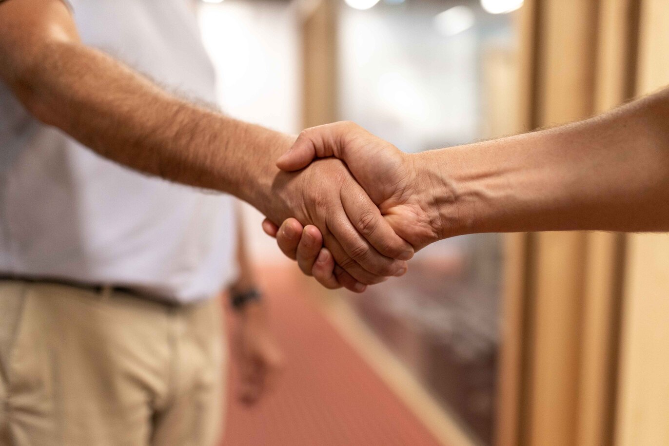 gros plan sur une poignée de main entre le dirigeant de Kubs et un client pour sceller un engagement