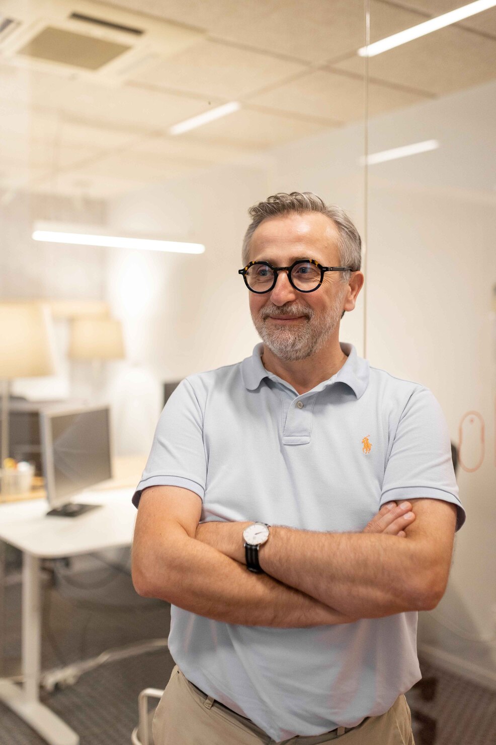 Directeur de Kubs souriant devant son bureau dans les locaux de l'entreprise